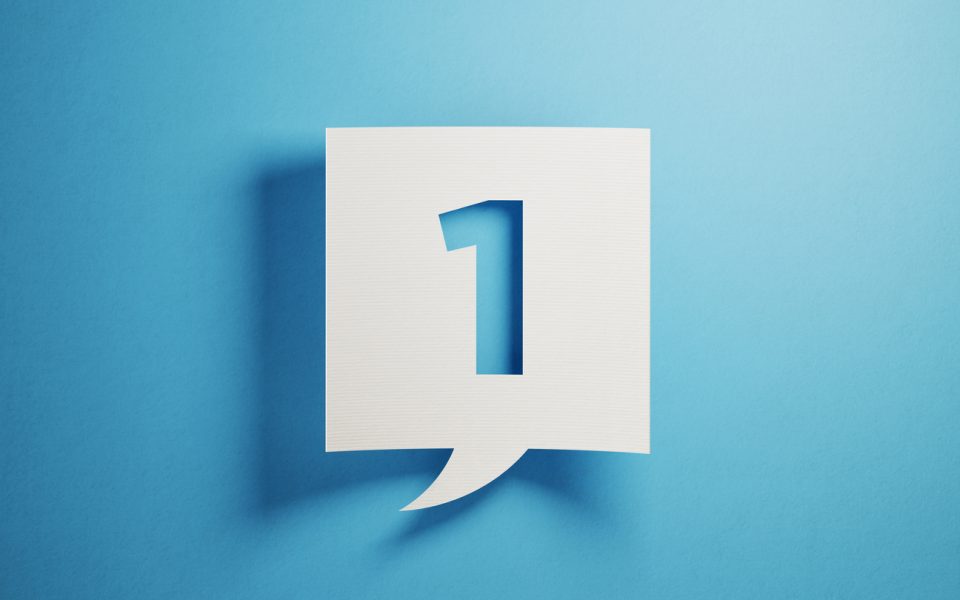 White chat bubble on blue background. Number one writes on chat bubble. Horizontal composition with copy space.