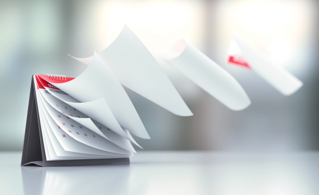 Pages Of A Red Calendar Standing Over Defocused Background Are Flying Away