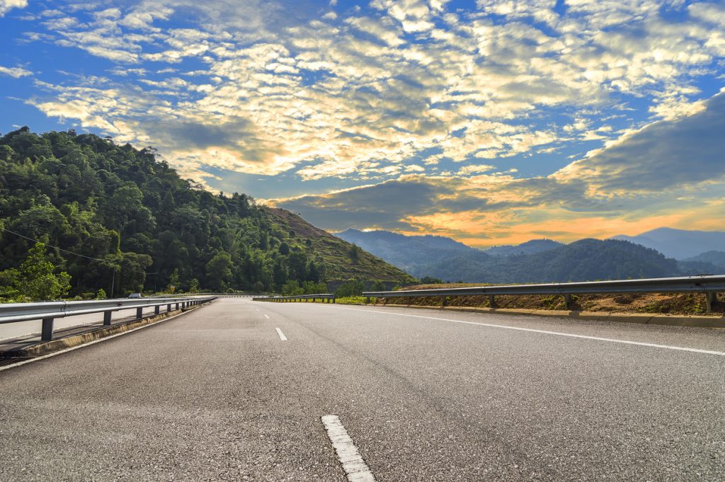 asphalt road in mountain hill with sunset background